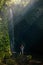 Woman stand in pool under waterfall, see on falling water