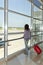 Woman standing at the airport window .