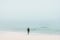 Woman standing alone on beach thinking with foggy ocean view