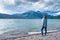 Woman standing along lakefront admiring mountains