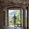 Woman standing in the arch of an old brick bastion and looking at a beautiful Mediterranean landscape