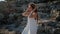 Woman is standing on basalt rocks in summer day