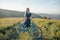 Woman standing with bicycle cruiser on rural summer road.