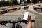 Woman standing with bicycle and showing the phone with blank white screen