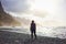 Woman standing on black sand volcanic Beniho Benijo Beach - North part of Tenerife. Canary Islands. Spain