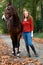 Woman standing brown mare horse avenue lane forest