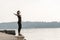 Woman standing on a cement bollard on a quay