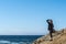 Woman standing on cliff looking onto the pacific ocean in Bodega Bay Northern California