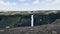 Woman standing on the cliff overlooking Haifoss waterfall, Iceland