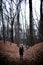 Woman standing in dark cold forest background