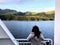 A woman standing on the deck of the inside passage ferry admiring the incredible views of the ocean and forest