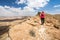 Woman standing desert mountain edge.