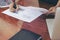 Woman standing at desk and working writing document hand close up.