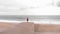 Woman is standing on edge of pier, looking beautiful landscape of stormy sea and grey clouds. Active life and sport concept. Runni