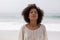 Woman standing with eyes closed on the beach