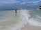 Woman standing and facing big sea wave splash