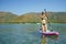 Woman standing firmly on SUP board and paddling
