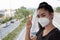 Woman standing hand sign of 2 fingers with putting on respirator N95 mask to protect from airborne respiratory diseases as the flu