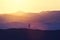 Woman standing on the hill, practicing yoga.