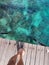 Woman standing on the jetty with beautiful clear water from the surface in Mabul Island, Semporna. Tawau, Sabah. Malaysia.