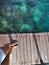 Woman standing on the jetty with beautiful clear water from the surface in Mabul Island, Semporna. Tawau, Sabah. Malaysia.