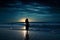 Woman standing on a moonlit beach, waves gently lapping at her feet