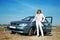 Woman standing near blue car