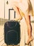 Woman standing one leg on suitcase, summertime