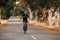 Woman standing out of the saddle on road bike while riding. Pro cyclist exercising on empty road