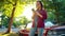 Woman is standing outdoors near the red vintage car and using smartphone