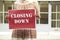 Woman Standing Outside Empty Shop Holding Closing Down Sign