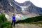 Woman standing on rocks by glacier lake.