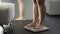 Woman standing on scales to see result of healthy dieting, normal weight range