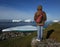 Woman Standing on Shore by Icebergs