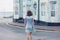 Woman standing in street outside blue house