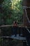 Woman standing on suspension platform on red wood forest