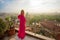 Woman standing on terrace and overlooking city in early morning