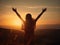 Woman standing on top of a mountain with her arms raised in the air