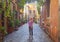 The woman is standing in typical beautiful Italian courtyard porch decorated with flowers