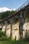 Woman standing under ancient railway viaduct in Vorokhta village, Ukraine