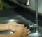 A woman standing and washing her hands at the sink to prevent germs protect colona virus, covid 19  DIGITAL CAMERA