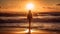 Woman standing in the water at the beach bathed in golden afternoon sunshine. View from behind, no face visible