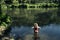 Woman standing in the water of a forest river in a mountainous area. Portugal.