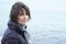 Woman standing in windy conditions in front of the sea