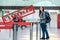 A woman stands at the airport with a backpack, waiting for the plane to take off. Blurred. Cancelled sign.The concept of a ban on