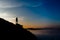 Woman stands alone on the rock of mountain.Colorful mist in valley silhouette scene