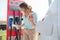 A woman stands at the charging station and holds a plug