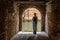 Woman stands at exit to canal from courtyard, Venice, Italy