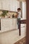 A woman stands in front of the sink in the kitchen and rinses the greens