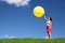 Woman stands on grass and starts inflatable ball